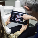 Dentist explaining wisdom teeth X-ray to a patient using a digital tablet