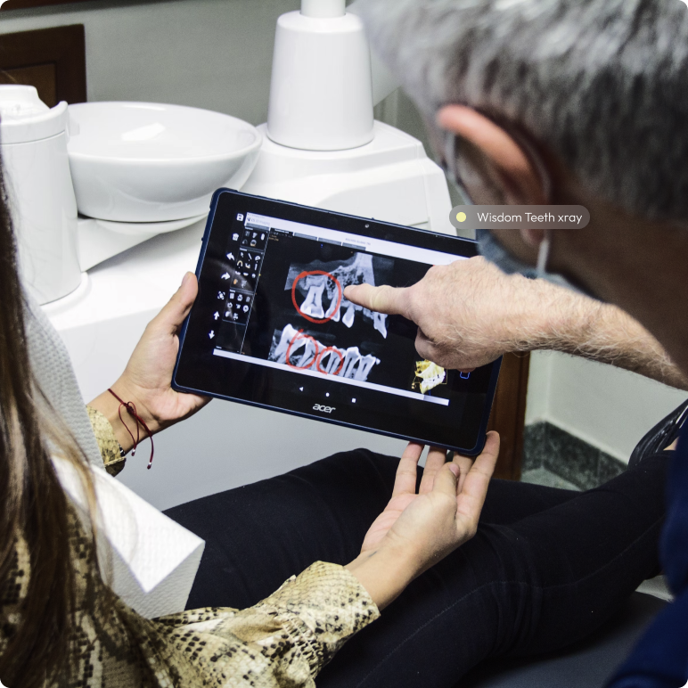 Dentist explaining wisdom teeth X-ray to a patient using a digital tablet